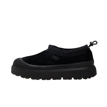 Black slip-on shoe with a brand logo on a white background