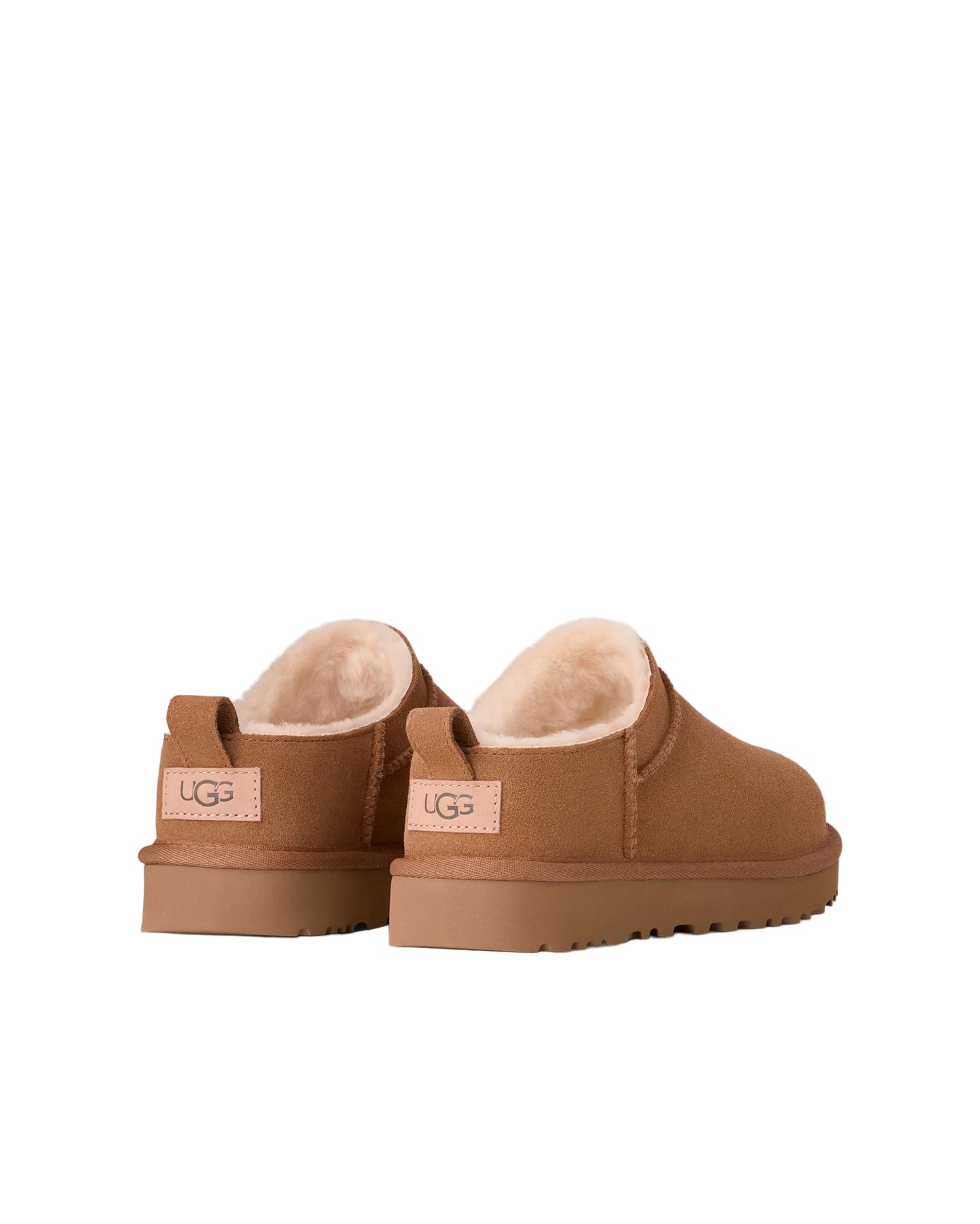 Pair of brown UGG slippers on a white background