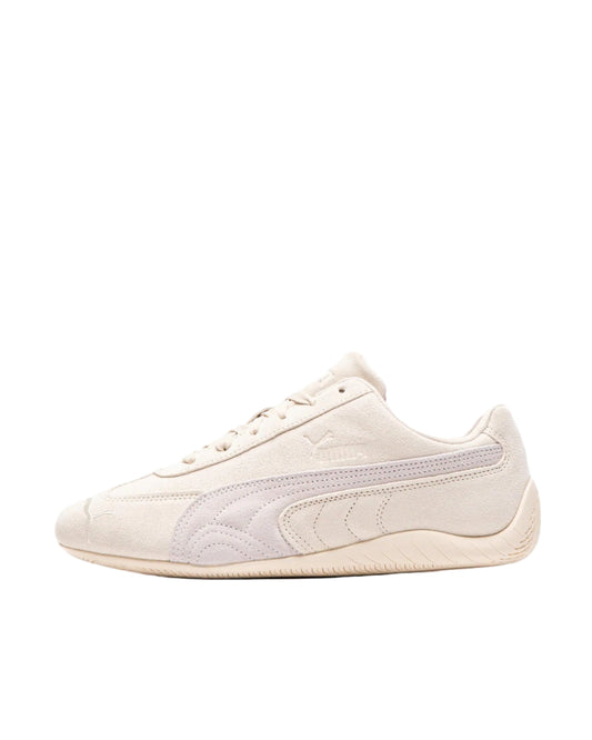 White sneaker with a subtle pattern on a light beige background