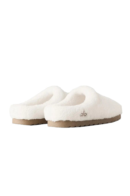 Pair of white slippers with a brand logo on a light gray background