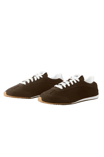 Pair of brown sneakers with white laces on a light gray background