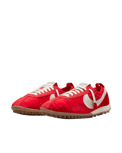 Red sneakers with white laces and swoosh logo on a light gray background