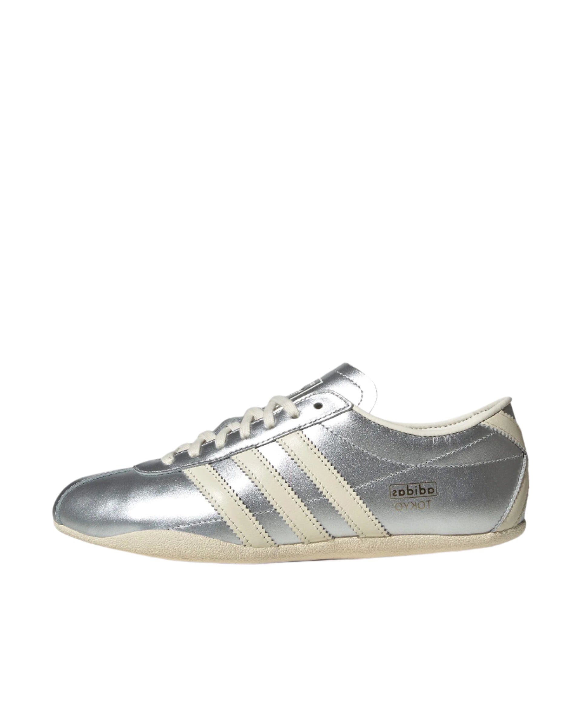 Silver Adidas sneaker with white stripes on a white background