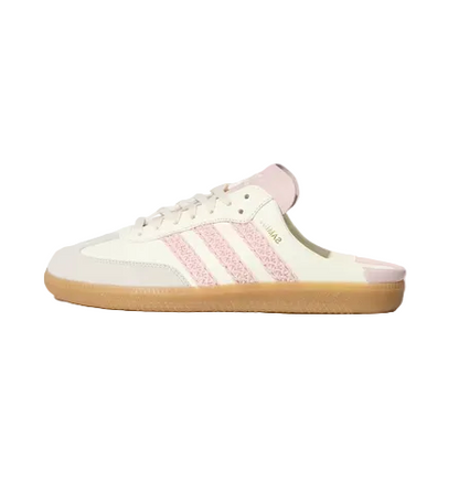 An Adidas Samba slip-on mule sneaker in cream and light pink, featuring pink glittery three-stripes and a gum sole, shown against a light gray background.