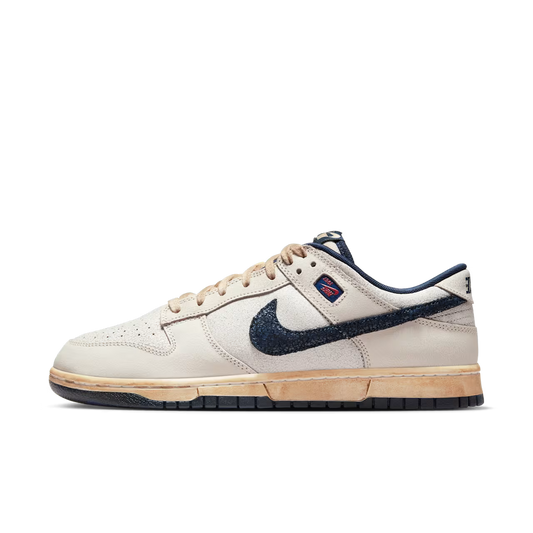 Beige sneaker with navy swoosh logo on a white background