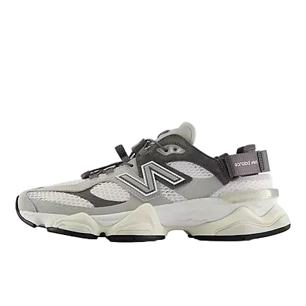 A New Balance chunky sneaker in gray, white, and black, featuring a thick sculpted sole and the signature 'N' logo on the side, set against a light gray background.